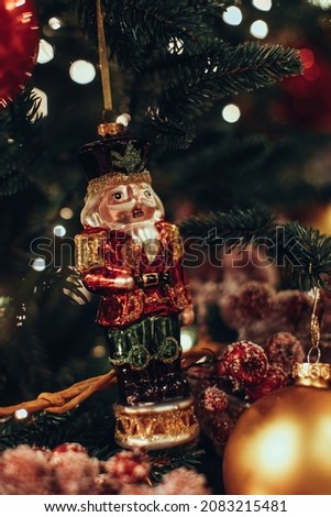 Christmas toy Nutcracker figurine hanging on the Christmas tree. Traditional festive decor, New Year details