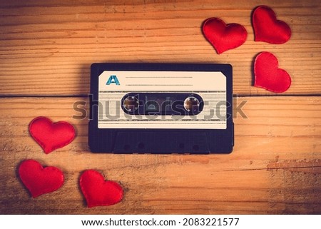 Toned Photo of Old Audio Tape Cassette with a Red Hearts on the Wooden Planks Background