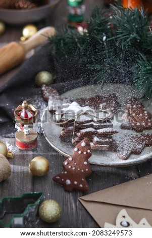 Christmas cookies in the shape of a Christmas tree on a wooden table with Christmas tree toys and fir branches