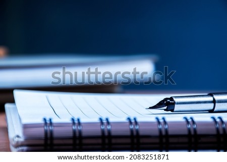Sliver ballpoint pen and notebook on table Royalty-Free Stock Photo #2083251871