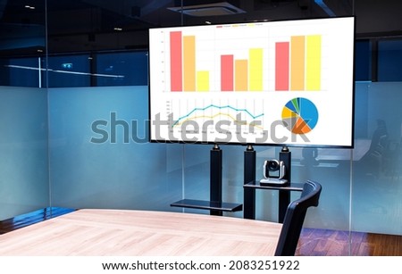 Mock up chart slide show presentation on display television with camera webcam in meeting room