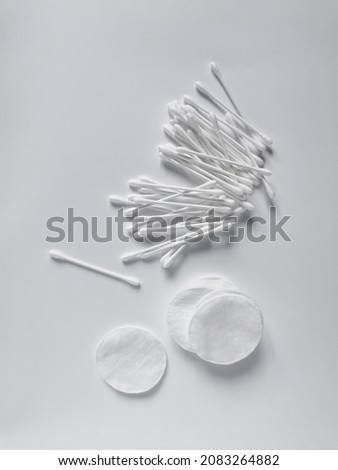 White cotton swabs and pads for daily feminine hygiene and care for the face and ears. Flat lay composition on the white background.