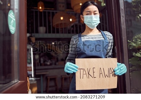 Woman waitress holding take away sign before coffee shop