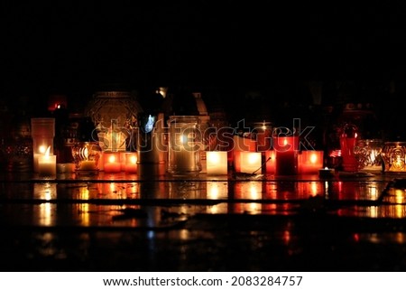 picture of lighting candles at cemetery. celebrating all saints day. november 1. autumn holidays. souls. memorial. lantern.