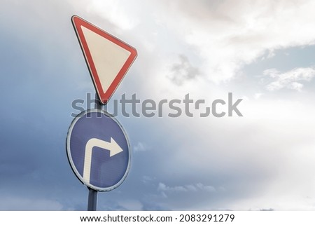 road sign sign attention and right turn on the background of dramatic sky and clouds