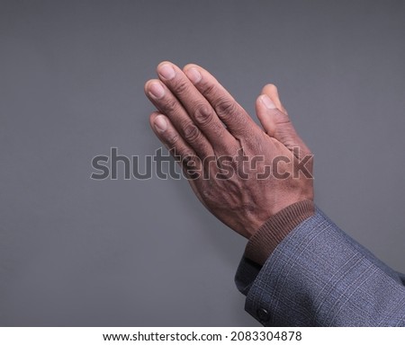 man praying to god with hands together with grey background stock photo