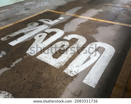 White Thai letters of words says "Park" on the road in front of hospital and to stop others car to park. park, letter, road.