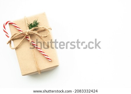 Brown gift box with festive decoration for Christmas and new year is on white background. Top view with copy space, flat lay.