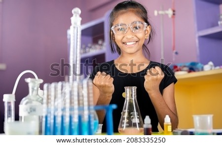 Excited Kid celebrating over successful science experiment result or chemical reaction at chemistry laboratory - concept of child prodigy, intelligent and smart. Royalty-Free Stock Photo #2083335250