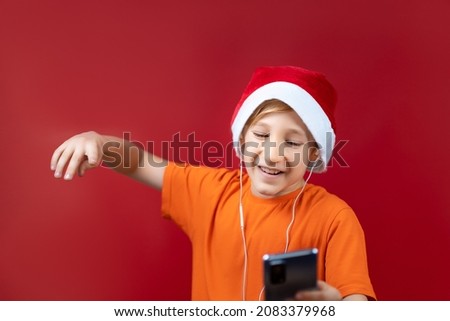 a boy in a Santa hat saw a Christmas message on his phone and was very happy