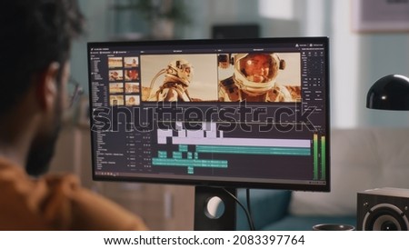 Unrecognizable guy editing astronaut video Royalty-Free Stock Photo #2083397764