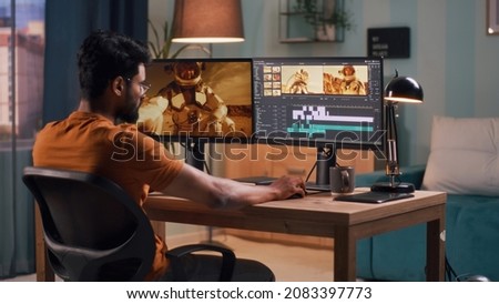 Unrecognizable guy editing astronaut video Royalty-Free Stock Photo #2083397773