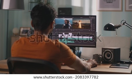 Man editing video on computer Royalty-Free Stock Photo #2083397782