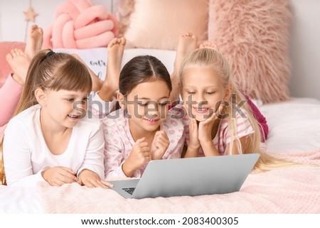 Cute little girls watching cartoons at home