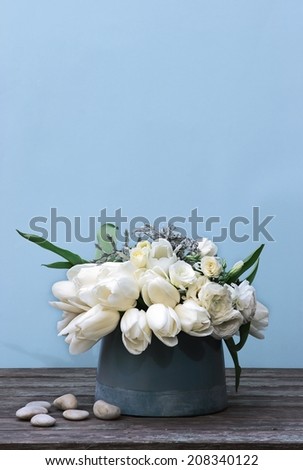 white flowers in ceramic vase on rustic table
