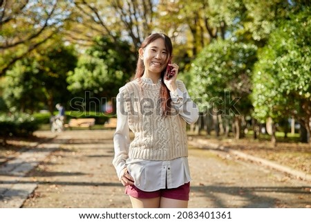 Asian female making a phone call in the park
