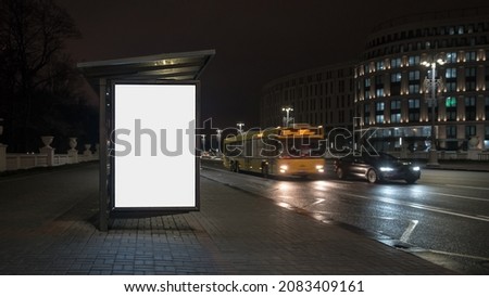 Blank white lightbox with empty place for mockup on city street at night with vehicle traffic. Concept commercial public information and advertising marketing.