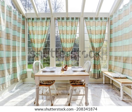 Bright sun room with bench and dining table set