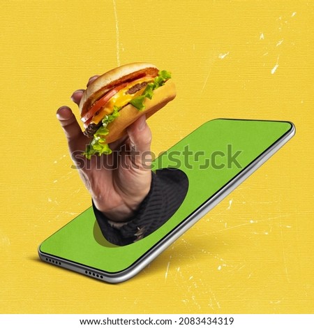 Contemporary art collage of male hand holding burger sticking out phone screen isolated over yellow background. Concept of delivery service, online shopping, food, technology. Copy space for ad