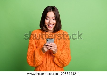 Portrait of attractive cheerful amazed girl using device gadget app smm post isolated over bright green color background Royalty-Free Stock Photo #2083443211
