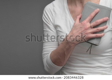 woman praying to God with bible on grey background stock photo 