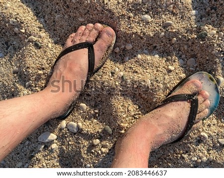 Low Section Of Man Relaxing At Sandy Beach . Royalty-Free Stock Photo #2083446637