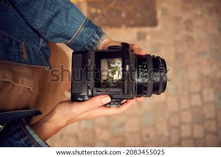 Close Up Of Woman In City Taking Photo On Retro Medium Format Film Camera To Post To Social Media