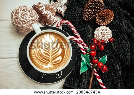 Cup of coffee on a saucer with christmas decoration on a white wood background