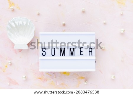 Word SUMMER on pink with seashell decoration and white pearls background. Sea vacation, holiday concept, flat lay, top view, copy space