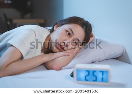 Asian women opened eyes lying on the bed have an insomnia problems. Royalty-Free Stock Photo #2083481536