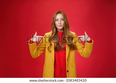 Self-assured assertive and optimsitic charming female entrepreneur with ginger hair in yellow coat pointing at herself proudly brag own success or willing to be candidate smiling confident