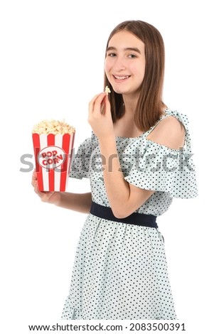 Teenage girl eating popcorn, standing on white. High resolution photo.