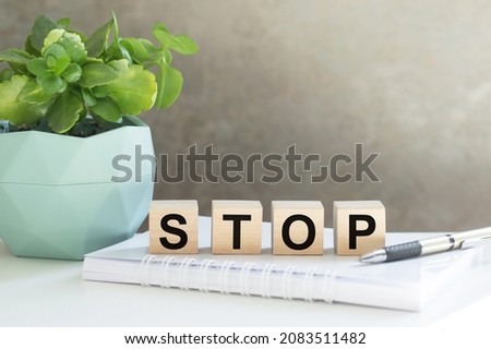 Four wooden cubes arranged in stack with word STOP on them on the office table