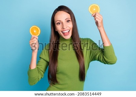 Photo of mature cute lady hold fruits wear green pullover isolated on blue color background