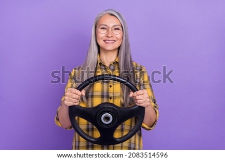 Photo of senior cheerful lady ride automobile trip study eyewear isolated over purple color background