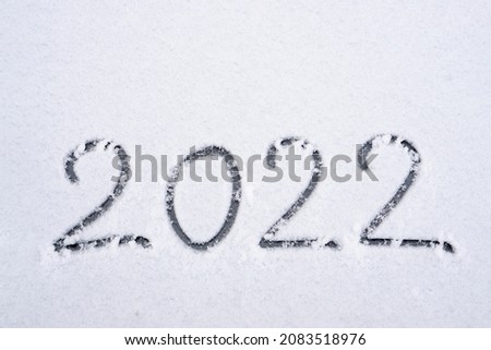 the inscription about the beginning of the new year 2022, the numbers are drawn on the snow in the winter season