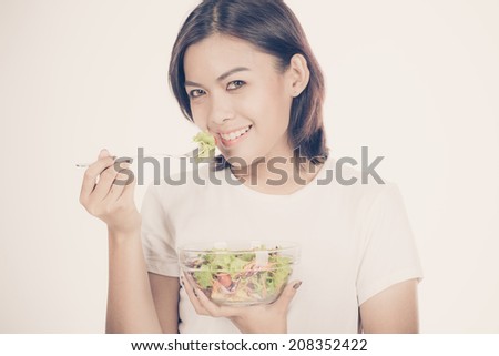 Portrait of a fit healthy hispanic woman eating a fresh salad isolated on white
