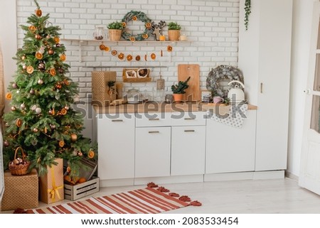 New year 2022 American kitchen interior. Christmas tree decorated with pieces of dried oranges, Wreath above the table, natural colors, organic living. selective focus