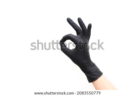hand in black glove shows ok gesture on white isolated background