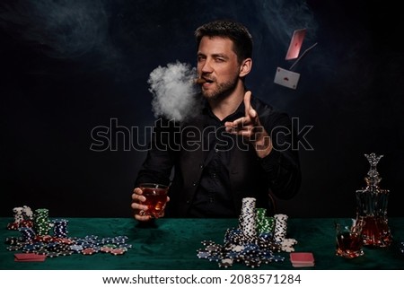 Bearded casino player man playing poker on green table Royalty-Free Stock Photo #2083571284