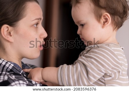 Portrait Adorable Face Of Little Cheerful Happy Toddler Daughter child baby Charming Smile Look At Mom Strong Cuddles Loving Mommy Together. show emotion surprise delight joy sincere feelings laughter