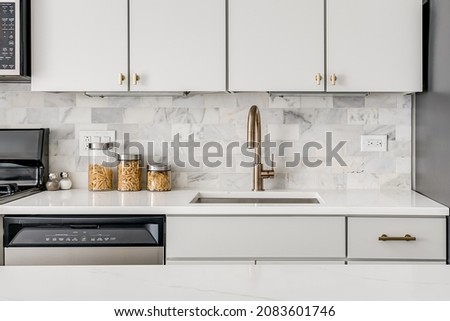 Modern White Kitchen Sink with Gold Faucet and White Counter Royalty-Free Stock Photo #2083601746