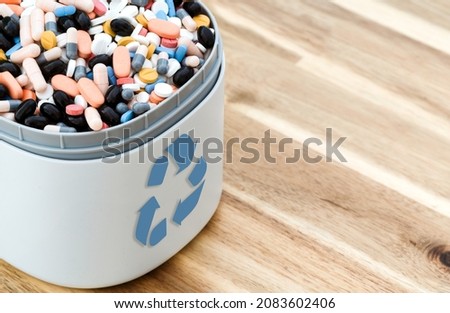 Full of expired pills and medicines in the trash bin with recycling symbol. Waste pills collected to be recycled. waste management concept.