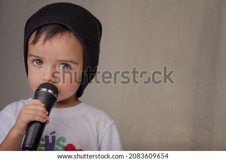 Little boy singing rap with microphone