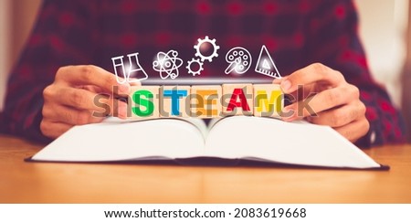 STEAM or STEM. Science, technology, engineering, art, mathematics icon. Education on teenager kid hand with "STEAM" on wooden block.Education innovation for student at school and homeschool.curriculum