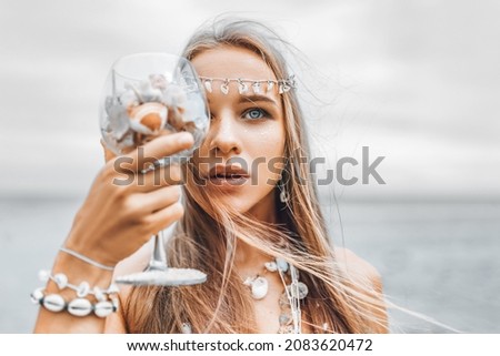 beautiful young stylish woman close up portrait with glass full of sea shells