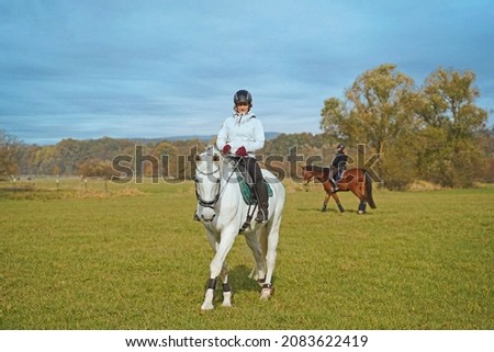 white horse and rider riding on the meadow in Bavaria extra for a photo shoot.