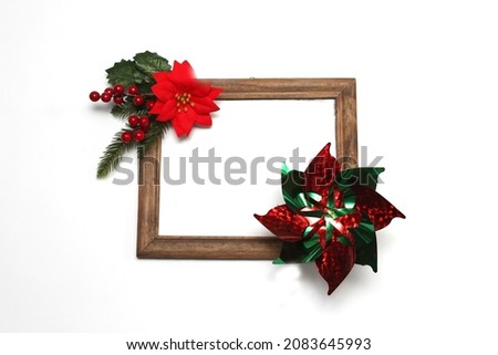 Photo frame surrounded by poinsettia flowers, canes and pinwheels as a Christmas prayer for a Christmas message
