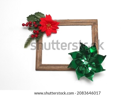 Photo frame surrounded by poinsettia flowers, canes and pinwheels as a Christmas prayer for a Christmas message

