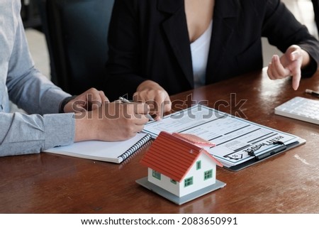 Real estate agent talked about the terms of the home purchase agreement, customer sign the documents to make the contract legally, Home sales and home insurance concept